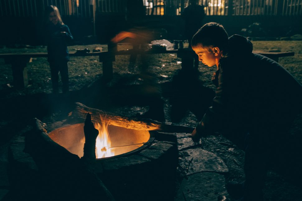 autism camps, child by a campfire